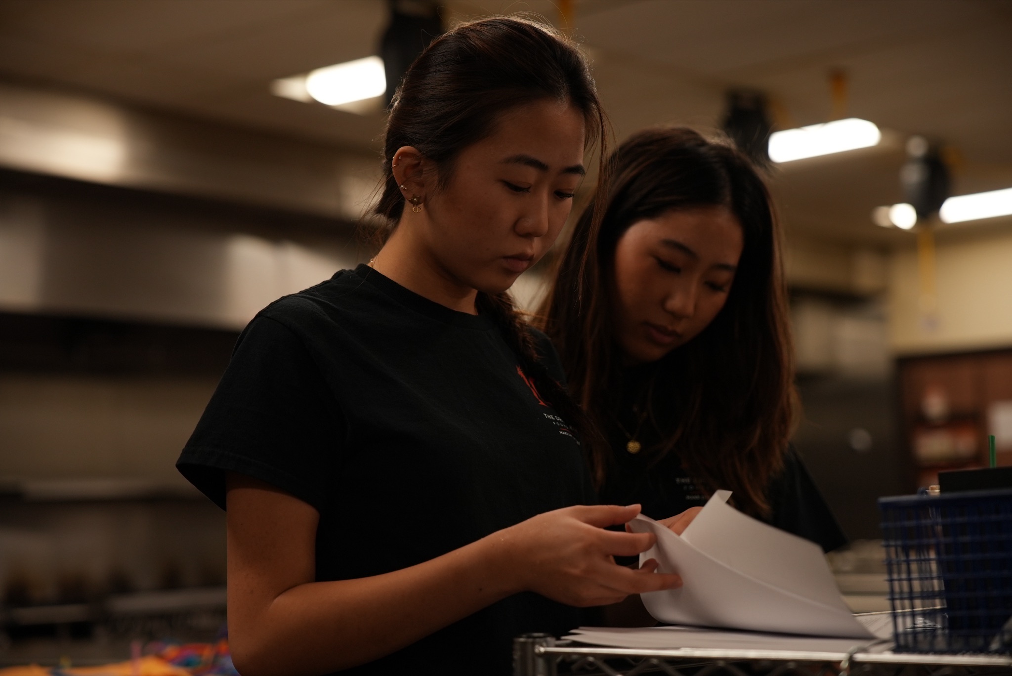 Michelle reviewing lesson materials with another volunteer in a commercial kitchen